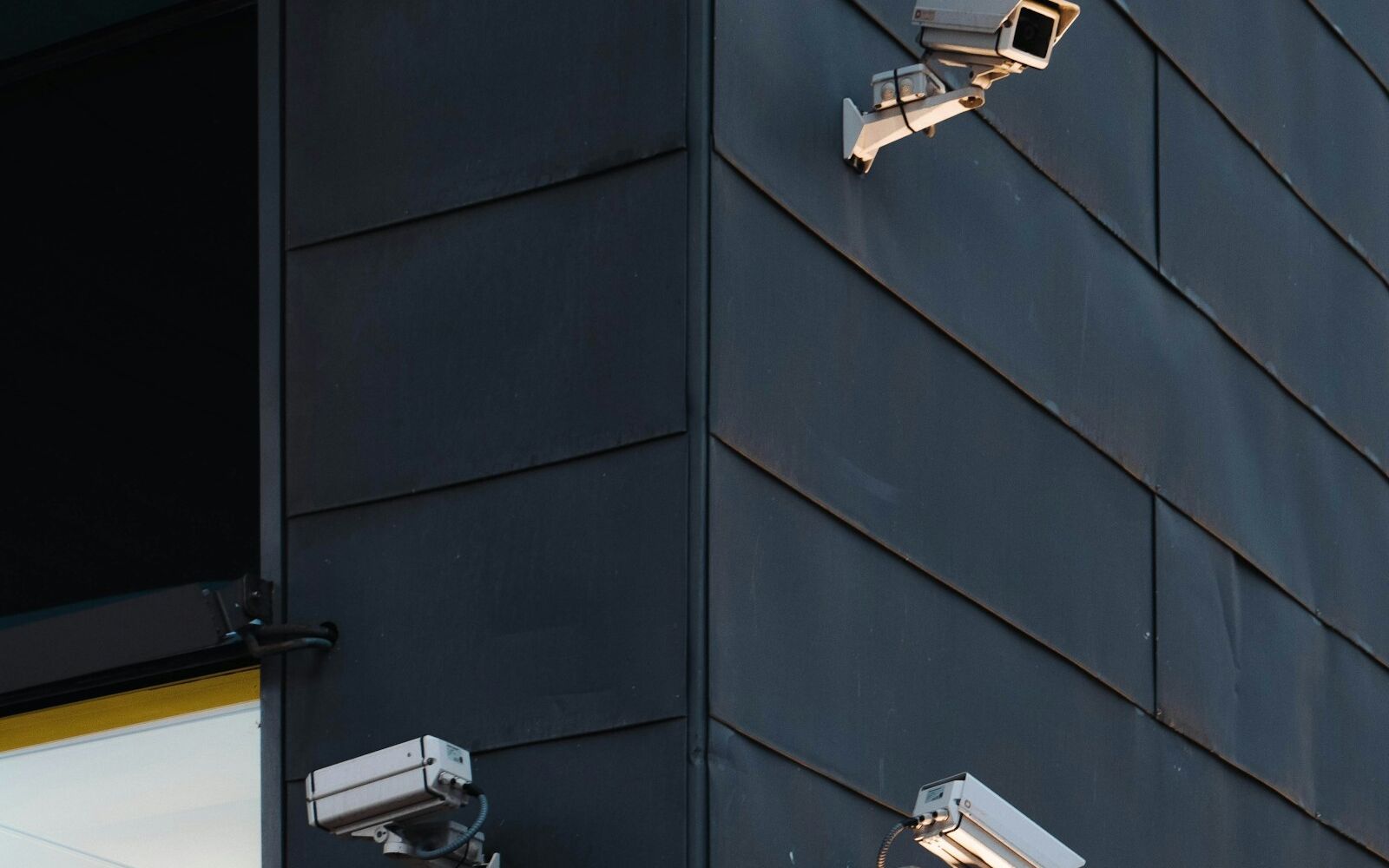 Three security cameras covering the corner of a building