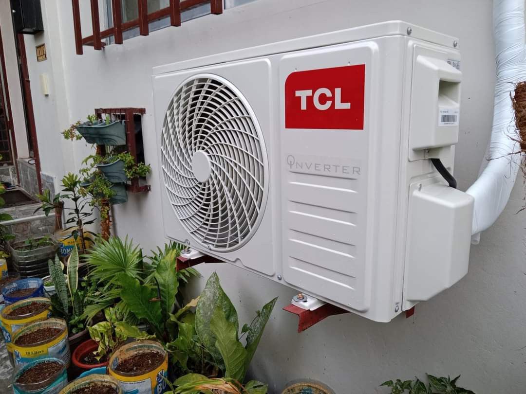 An outdoor air conditioning unit against a brick wall